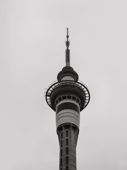 Black and white image of Auckland's Sky Tower against overcast sky