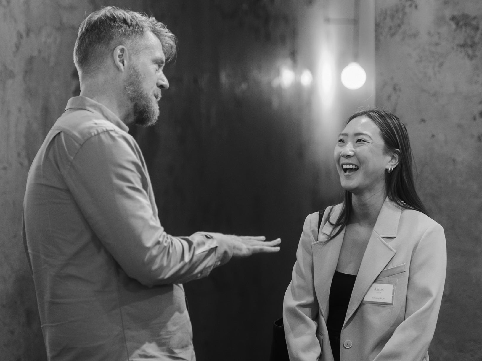 Black and white photo of two professionals engaged in conversation at networking event