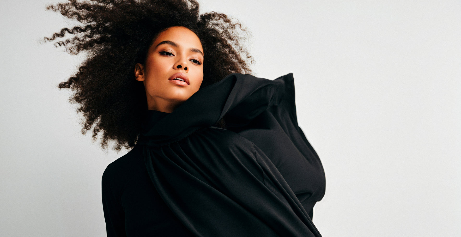 Portrait of a woman wearing a structural black silk top.