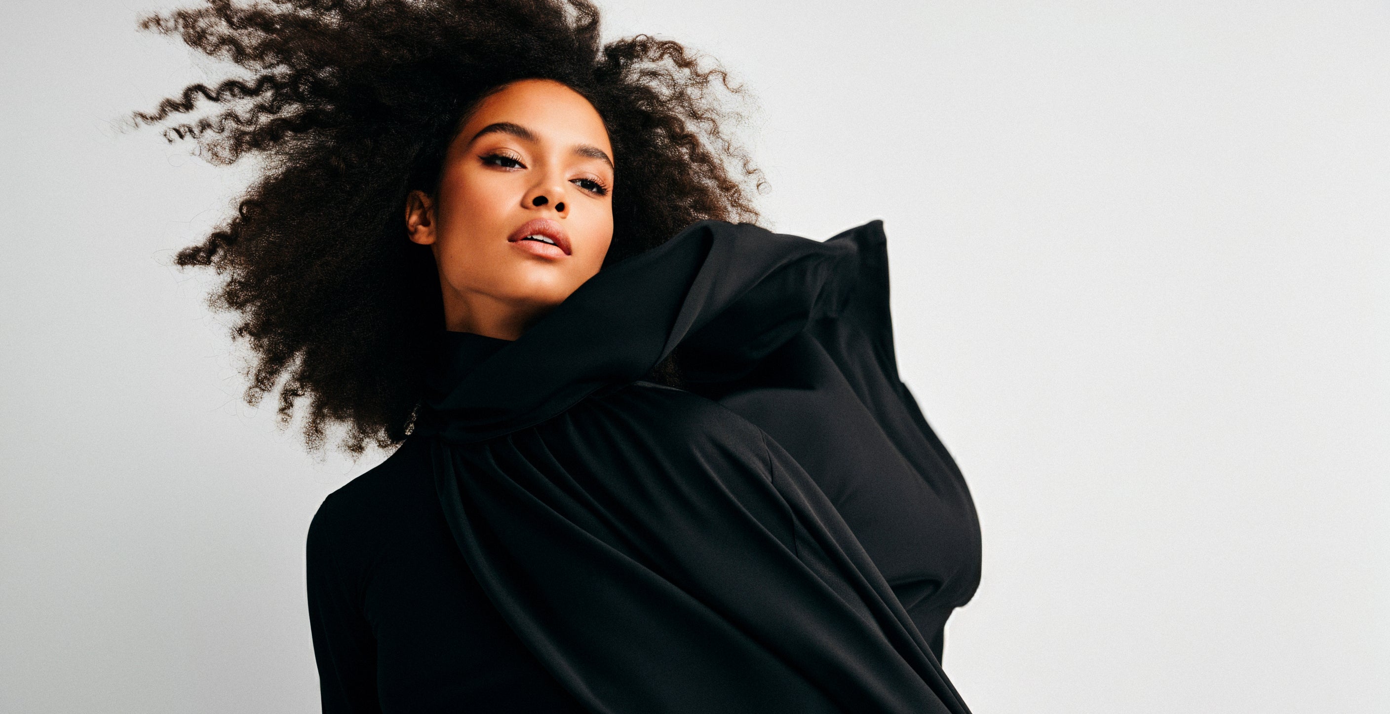 Portrait of a woman wearing a structural black silk top.