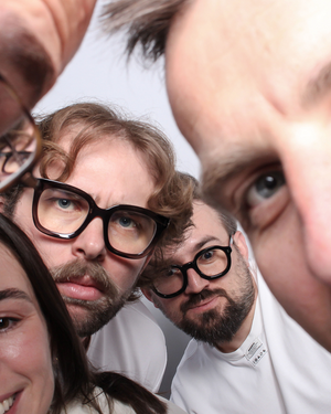 Close-up of four people with a focus on their facial expressions and glasses.