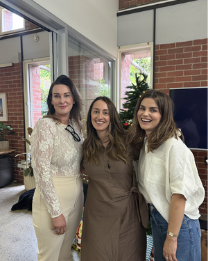 Three people at office holiday party in front of Christmas tree