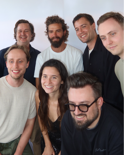 Team photo of eight people in photo booth at Christmas Party
