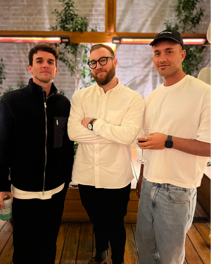Three people at networking event in industrial loft space