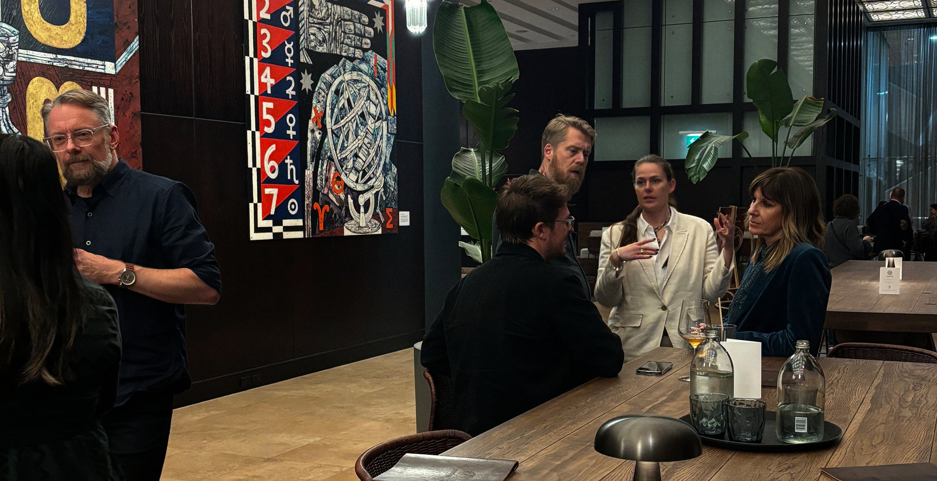 Group of people in a modern restaurant setting with decor and artwork.