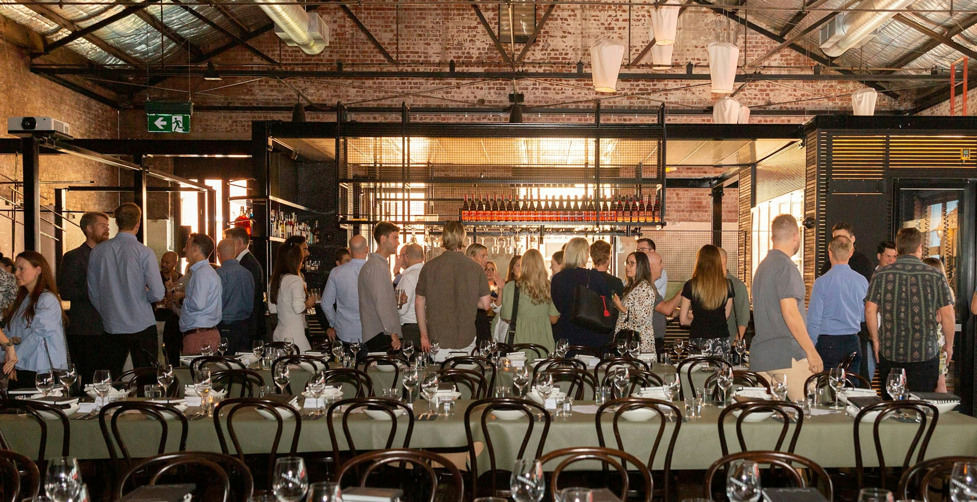 Group of people gathered around a long table in a rustic indoor setting.