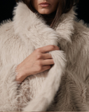 Close-up of a person wearing a fur coat against a blurred background